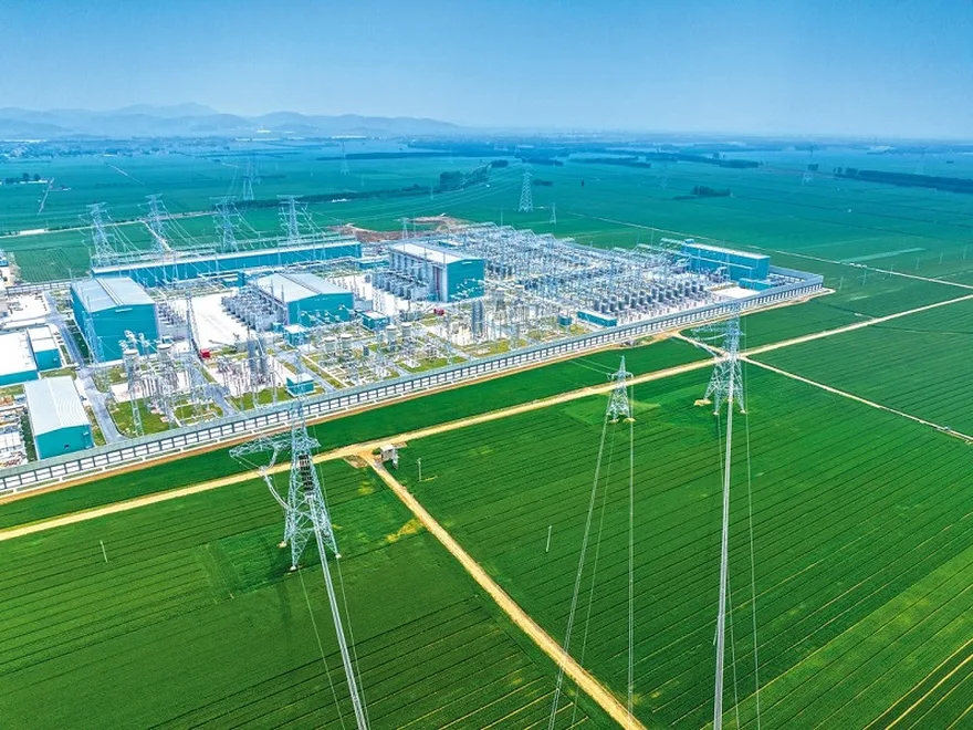 Aerial view of a large HVDC converter station with valve halls, converter transformers and switchyard